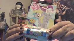 Size: 912x513 | Tagged: safe, imported from derpibooru, derpy hooves, pegasus, pony, female, lip balm, mare, merchandise, muffin, that one nameless background pony we all know and love