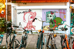 Size: 1200x800 | Tagged: safe, artist:ficficponyfic, edit, imported from derpibooru, oc, oc only, oc:emerald jewel, earth pony, pony, colt quest, bicycle, building, child, clothes, colt, crossdressing, cute, flower, flower in hair, graffiti, hair over one eye, hoodie, irl, male, photo, photofunia, text