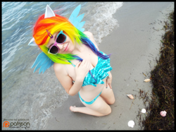 Size: 2000x1496 | Tagged: safe, artist:krazykari, imported from derpibooru, rainbow dash, human, beach, belly button, bikini, clothes, cosplay, costume, irl, irl human, kneeling, patreon, patreon logo, photo, solo, sunglasses, swimsuit