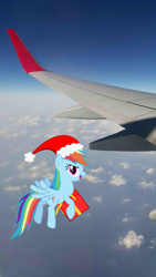 Size: 2988x5312 | Tagged: safe, artist:livehotsun, imported from derpibooru, rainbow dash, hat, irl, photo, plane, ponies in real life, present, santa hat, sky, solo, vector