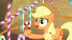 Size: 1280x720 | Tagged: safe, imported from derpibooru, screencap, applejack, earth pony, pony, the great escape room, candy, candy cane, female, food, freckles, hay, holding, mare, solo