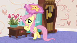 Size: 1280x720 | Tagged: safe, imported from derpibooru, screencap, fluttershy, pegasus, pony, discordant harmony, bipedal, bipedal leaning, chair, clock, couch, cute, female, flower, grandfather clock, leaning, mare, pot, pushing, shyabetes, smiling, solo, table