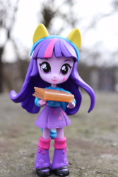 Size: 4000x6000 | Tagged: safe, artist:artofmagicpoland, imported from derpibooru, twilight sparkle, equestria girls, book, carrying, clothes, doll, equestria girls minis, eqventures of the minis, female, holding, leg warmers, offering, secrets, shoes, skirt, solo, sweater, toy