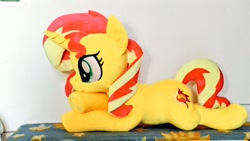 Size: 1024x576 | Tagged: safe, artist:nekokevin, imported from derpibooru, sunset shimmer, pony, unicorn, crossed hooves, cute, female, irl, lying down, mare, photo, plushie, shimmerbetes, smiling, solo, underhoof