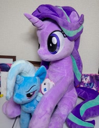 Size: 929x1200 | Tagged: safe, artist:nekokevin, imported from derpibooru, starlight glimmer, trixie, pony, unicorn, series:nekokevin's glimmy, 4de, duo, female, irl, mare, narrowed eyes, photo, plushie, sitting, size difference, smiling, table