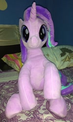 Size: 714x1200 | Tagged: safe, artist:nekokevin, imported from derpibooru, starlight glimmer, pony, unicorn, series:nekokevin's glimmy, bed, female, irl, looking at you, mare, photo, pillow, plushie, raised hoof, sitting, smiling, solo