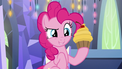 Size: 1920x1080 | Tagged: safe, imported from derpibooru, screencap, pinkie pie, earth pony, pony, cupcake, female, food, holding, mare, raised hoof, smiling, solo