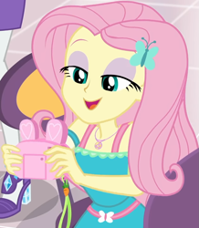 Size: 857x985 | Tagged: safe, imported from derpibooru, screencap, fluttershy, rarity, equestria girls, equestria girls series, holidays unwrapped, spoiler:eqg series (season 2), bunny ears, camera, canterlot mall, chair, clothes, cropped, cute, dashing through the mall, dress, female, flower, fluttershy boho dress, geode of fauna, gift giving, hairclip, happy, jewelry, lidded eyes, looking down, magical geodes, mall, necklace, present, shyabetes, sitting, smiling, table, waistband