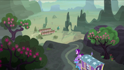 Size: 1440x810 | Tagged: safe, imported from derpibooru, screencap, starlight glimmer, trixie, pony, unicorn, to where and back again, desert, duo, female, flower, hat, mare, our town, scenery, tree, trixie's wagon, village, wizard hat