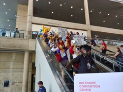 Size: 4656x3492 | Tagged: safe, artist:atalonthedeer, imported from derpibooru, human, bronycon, bronycon 2019, baltimore convention center, bronies are diet furries, escalator, furry, fursuit, irl, irl human, photo