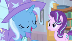 Size: 1600x900 | Tagged: safe, imported from derpibooru, screencap, starlight glimmer, trixie, pony, unicorn, a horse shoe-in, book, bookshelf, cape, clothes, female, hat, library, mare, shelf, trixie's cape, trixie's hat