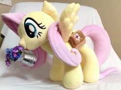 Size: 1185x884 | Tagged: safe, artist:c20710, imported from derpibooru, fluttershy, pegasus, pony, bag, first aid kit, flower, irl, photo, plushie, saddle bag, solo, spread wings, watering can, wings