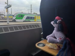 Size: 4128x3096 | Tagged: safe, imported from derpibooru, twilight sparkle, pony, unicorn, cake, crochet, food, irl, looking up, photo, plushie, poland, sitting, solo, train, train station, unicorn twilight, warsaw