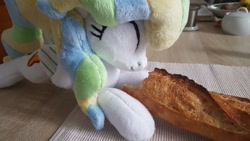 Size: 1207x679 | Tagged: safe, artist:ketika, imported from derpibooru, vapor trail, pegasus, pony, baguette, bread, cute, eating, eyes closed, food, happy, irl, kitchen, lying down, photo, plushie, solo, table, vaporbetes