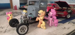 Size: 3264x1546 | Tagged: safe, imported from derpibooru, apple bloom, applejack, derpy hooves, pinkie pie, rainbow dash, blind bag, chassis, chevrolet impala, engine, everfree customs, female, ford crown victoria police interceptor, garage, irl, mechanic, photo, pontiac gto, toy, v8, volkswagen beetle