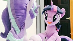 Size: 1024x576 | Tagged: safe, artist:nekokevin, imported from derpibooru, starlight glimmer, twilight sparkle, pony, unicorn, series:nekokevin's glimmy, duo, female, irl, looking at each other, mare, open mouth, photo, plushie, raised hoof, rear view, sitting, smiling, underhoof, unicorn twilight