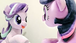 Size: 1024x576 | Tagged: safe, artist:nekokevin, imported from derpibooru, starlight glimmer, twilight sparkle, pony, unicorn, series:nekokevin's glimmy, duo, female, irl, looking at each other, mare, open mouth, photo, plushie, raised hoof, sideways, sitting, smiling, underhoof, unicorn twilight