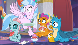 Size: 1460x857 | Tagged: safe, imported from derpibooru, screencap, gallus, ocellus, silverstream, smolder, changedling, changeling, classical hippogriff, dragon, griffon, hippogriff, she's all yak, aweeg*, cropped, cute, deck of cards, diaocelles, diastreamies, female, flying, gallabetes, group, juxtaposition bait, male, open mouth, plate, playing card, prone, puffy cheeks, shocked, shrunken pupils, sitting, smolderbetes, spread wings, wings