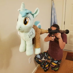 Size: 942x942 | Tagged: safe, artist:hoppip, imported from derpibooru, lyra heartstrings, human, pony, unicorn, clothes, duo, female, irl, irl human, lyra plushie, mare, not salmon, pants, photo, plushie, rocket launcher, rpg-7, wat