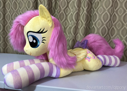 Size: 1595x1144 | Tagged: safe, artist:qtpony, imported from derpibooru, fluttershy, pony, bow, clothes, irl, lying down, photo, plushie, prone, socks, solo, striped socks, tail bow