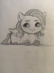 Size: 1536x2048 | Tagged: safe, artist:miokomata, imported from derpibooru, fluttershy, pegasus, pony, cheek fluff, chibi, cute, ear fluff, female, freckles, freckleshy, grayscale, looking at you, lying down, mare, monochrome, pencil drawing, prone, shyabetes, smiling, smiling at you, solo, traditional art