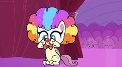 Size: 828x457 | Tagged: safe, imported from derpibooru, screencap, fluttershy, pegasus, pony, lolly-pop, my little pony: pony life, spoiler:pony life s02e19, backstage, bowtie, clown, clown makeup, clown nose, clown wig, crowd, curtains, cute, female, flutterclown, g4.5, logo, pony life, red nose, shyabetes, sitting, solo