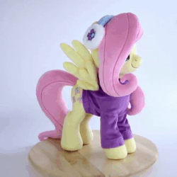 Size: 720x720 | Tagged: safe, artist:meplushyou, imported from derpibooru, fluttershy, pegasus, pony, animated, clothes, earmuffs, irl, no sound, photo, plushie, smiling, solo, sweater, turnaround, turntable, webm