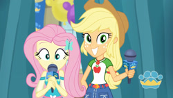 Size: 3410x1920 | Tagged: safe, imported from derpibooru, screencap, applejack, fluttershy, best in show: the pre-show, equestria girls, equestria girls series, spoiler:eqg series (season 2), applejack's hat, belt, best in show logo, clothes, cowboy hat, cute, cutie mark, cutie mark on clothes, denim skirt, female, geode of super strength, grin, hairpin, hat, jackabetes, jewelry, magical geodes, microphone, necklace, shyabetes, skirt, smiling