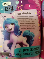 Size: 3120x4160 | Tagged: safe, imported from derpibooru, izzy moonbow, pony, unicorn, book, g5, hi new friend, irl, my little pony annual 2022, my little pony: a new generation, photo