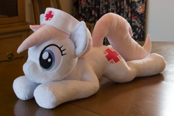 Size: 5184x3456 | Tagged: safe, artist:azgchip, imported from derpibooru, nurse redheart, earth pony, pony, cute, female, g4, hat, irl, lying down, mare, nurse hat, photo, plushie, pony plushie, prone, solo, sploot, table