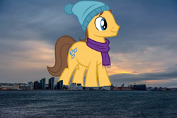 Size: 2000x1333 | Tagged: safe, artist:jaredking779, artist:sofunnyguy, imported from derpibooru, caramel, earth pony, pony, background pony, clothes, giant pony, giant/macro earth pony, hat, highrise ponies, iceland, irl, macro, male, mega giant, photo, ponies in real life, scarf, smiling, solo, stallion