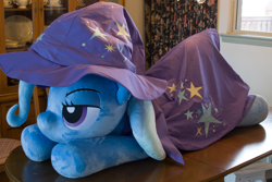 Size: 5184x3456 | Tagged: safe, artist:azgchip, imported from derpibooru, trixie, pony, unicorn, bedroom eyes, cape, clothes, female, hat, irl, life size, lying down, mare, photo, plushie, prone, solo, table, trixie's cape, trixie's hat