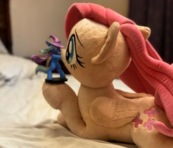 Size: 1703x1463 | Tagged: safe, imported from derpibooru, photographer:xbi, fluttershy, trixie, pegasus, pony, bed, cape, clothes, digital art, figurine, hat, irl, mixed media, on bed, photo, plushie, trixie's cape, trixie's hat, welovefine