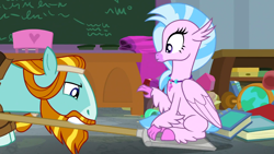 Size: 1920x1080 | Tagged: safe, imported from derpibooru, screencap, rockhoof, silverstream, classical hippogriff, earth pony, hippogriff, pony, a rockhoof and a hard place, season 8, spoiler:s08, chalkboard, classroom, colored hooves, desk, duo, female, jewelry, male, mare, necklace, rockhoof's shovel, shovel, sittin on shovel, sitting, stallion