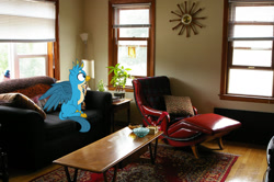 Size: 1600x1063 | Tagged: safe, artist:chainchomp2 edits, artist:jaredking779, edit, imported from derpibooru, gallus, griffon, pony, couch, irl, male, milwaukee, photo, pillow, ponies in real life, sitting, solo, spread wings, wings, wisconsin