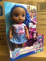 Size: 1500x2000 | Tagged: safe, imported from derpibooru, izzy moonbow, human, pony, unicorn, baby alive, dark skin, g5, irl, merchandise, official, photo, toy