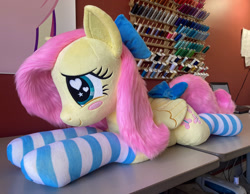 Size: 2336x1814 | Tagged: safe, artist:qtpony, imported from derpibooru, fluttershy, pegasus, pony, bow, clothes, cute, female, folded wings, hair bow, irl, lying down, photo, plushie, prone, quadrupedal, shyabetes, socks, solo, striped socks, wings