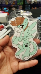 Size: 1152x2048 | Tagged: safe, artist:inkkeystudios, imported from derpibooru, oc, oc only, human, pegasus, pony, :3, badge, irl, irl human, looking at you, photo, smiling, solo, spread wings, traditional art, unshorn fetlocks, wings