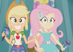 Size: 633x450 | Tagged: safe, imported from derpibooru, screencap, applejack, fluttershy, human, best in show: the pre-show, equestria girls, spoiler:eqg series (season 2), :|, belt, big smile, breaking the fourth wall, clothes, cowboy hat, cute, cutie mark on clothes, denim, denim skirt, duo, fluttershy boho dress, geode of fauna, geode of super strength, grin, hairpin, hand on arm, hat, jewelry, just friends, magical geodes, microphone, necklace, shirt, skirt, sleeveless, smiling, stetson, t-shirt