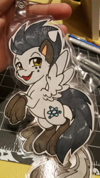 Size: 5312x2988 | Tagged: safe, artist:inkkeystudios, imported from derpibooru, oc, oc only, pegasus, pony, :3, badge, clothes, freckles, lidded eyes, looking at you, open mouth, open smile, paper pony, paw socks, photo, smiling, socks, solo, spread wings, traditional art, wings