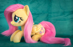 Size: 2227x1434 | Tagged: safe, artist:buttercupbabyppg, imported from derpibooru, fluttershy, pegasus, pony, cute, female, folded wings, irl, lying down, mare, photo, plushie, prone, shyabetes, smiling, solo, wings