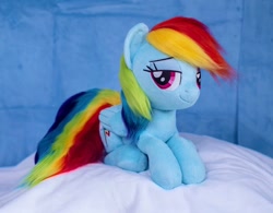 Size: 1200x938 | Tagged: safe, artist:buttercupbabyppg, imported from derpibooru, rainbow dash, pegasus, pony, female, folded wings, irl, lying down, mare, photo, plushie, prone, smiling, solo, wings