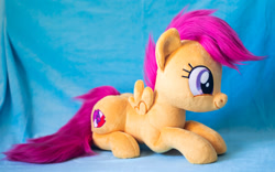 Size: 1914x1195 | Tagged: safe, artist:buttercupbabyppg, imported from derpibooru, scootaloo, pegasus, pony, female, filly, foal, happy, irl, lying down, photo, plushie, prone, smiling, solo, spread wings, wings