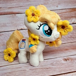 Size: 1200x1200 | Tagged: safe, artist:straycatcrafts, imported from derpibooru, pear butter, earth pony, female, filly, flower, foal, hair tie, happy, irl, photo, plushie, smiling, solo, younger