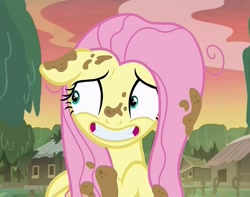 Size: 817x644 | Tagged: safe, imported from derpibooru, screencap, fluttershy, pegasus, pony, a health of information, cropped, dirt, female, floppy ears, grin, mare, mud, nervous, nervous grin, smiling, solo