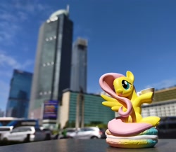 Size: 3453x3000 | Tagged: safe, imported from derpibooru, fluttershy, pegasus, pony, blurry background, city, cityscape, figure, food, high res, indonesia, irl, jakarta, macaron, photo, pop mart, skyscraper, solo