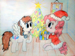 Size: 4032x3016 | Tagged: safe, artist:jakusi, pinkie pie, oc, earth pony, pegasus, pony, canterlot, christmas, christmas tree, clothes, costume, duo, duo female, female, gift giving, happy, hat, headphones, holiday, mare, pegasus oc, picture frame, present, santa costume, santa hat, sitting, traditional art, tree, wings