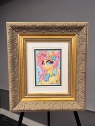 Size: 1536x2048 | Tagged: safe, artist:dandy, imported from derpibooru, fluttershy, butterfly, pony, babscon, blushing, butterfly hairpin, clothes, cute, dress, ear fluff, female, flower, flower in hair, framed picture, gala dress, heart, heart eyes, looking at you, mare gallery, photo, shyabetes, smiling, smiling at you, solo, traditional art, watercolor painting, wingding eyes