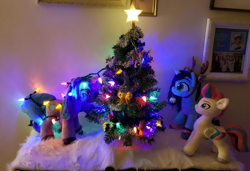 Size: 1792x1228 | Tagged: safe, artist:melodis, imported from derpibooru, izzy moonbow, zipp storm, pegasus, pony, unicorn, animal costume, christmas, christmas decoration, christmas lights, christmas tree, clothes, costume, decoration, female, g5, holiday, horn, irl, looking at each other, looking at someone, mare, misty brightdawn, photo, plushie, reindeer costume, tangled up, tree, trio, trio female