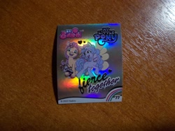 Size: 1024x768 | Tagged: safe, imported from derpibooru, izzy moonbow, sunny starscout, earth pony, unicorn, 2d, alarm, g5, heart, horn, indonesian, looking at you, looking away, merchandise, official, photo, rainbow, shiny, slogan, smiling, smiling at you, sticker